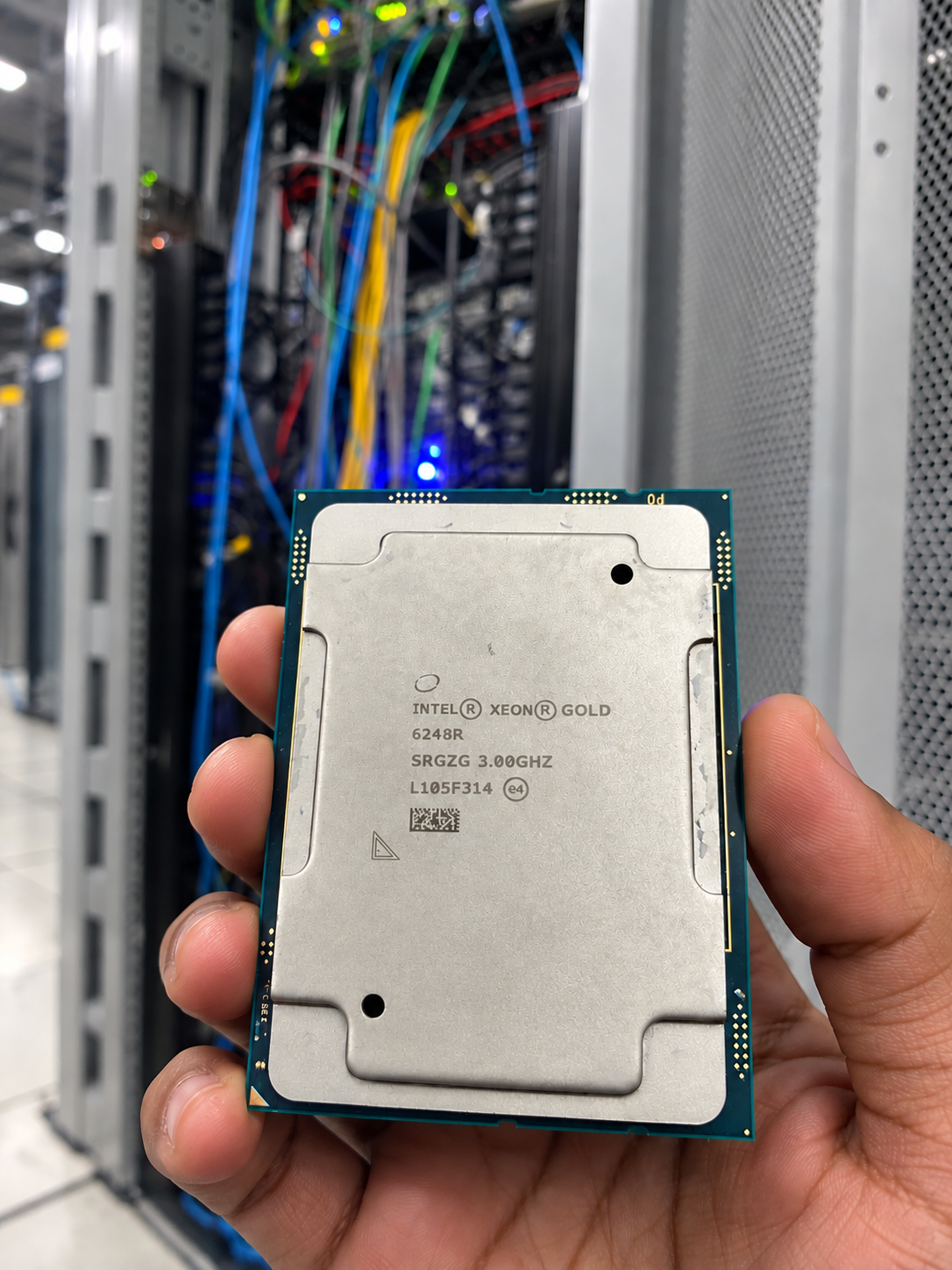 Intel Xeon Gold 6248R processor marked SRGZG 3.00GHZ, held in a data centre aisle.